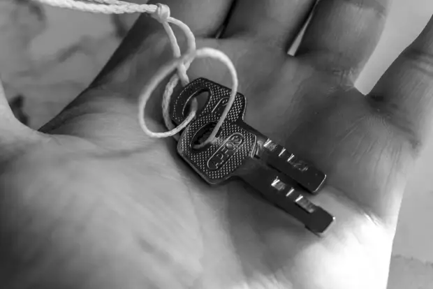 Two keys tied together resting in an open palm